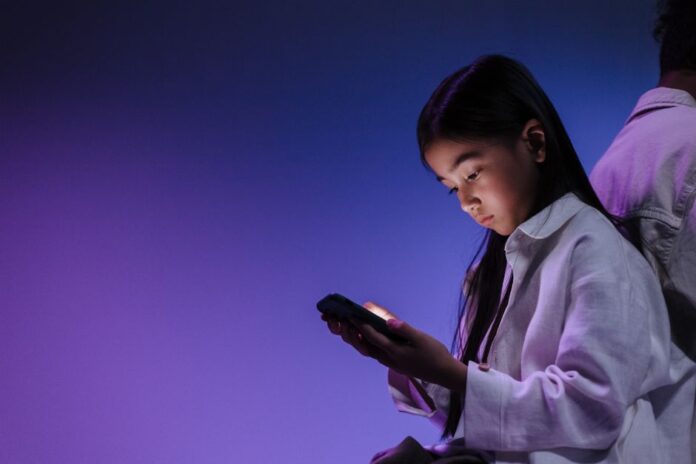 Teenager mit Smartphone in der Nacht